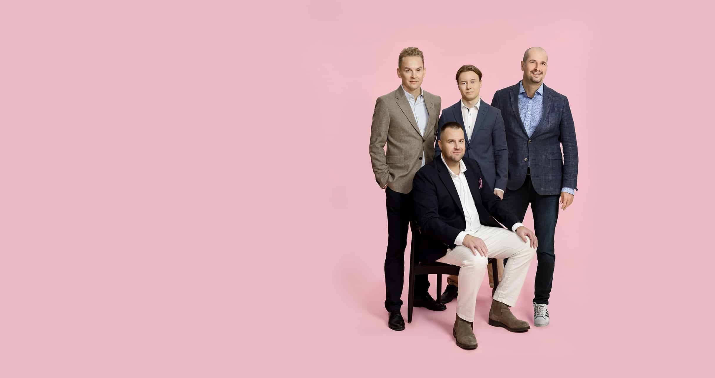 Visio varainhoito ryhmäkuva vaaleanpunaisella taustalla