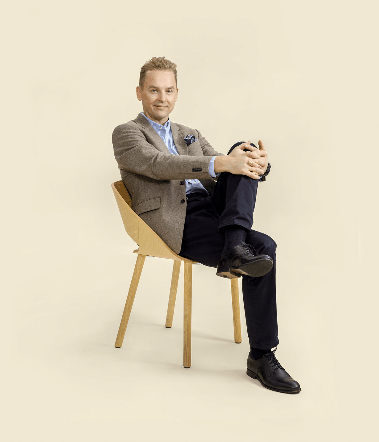 Tiimikuva Jouni Saario istuva vaalealle taustalla